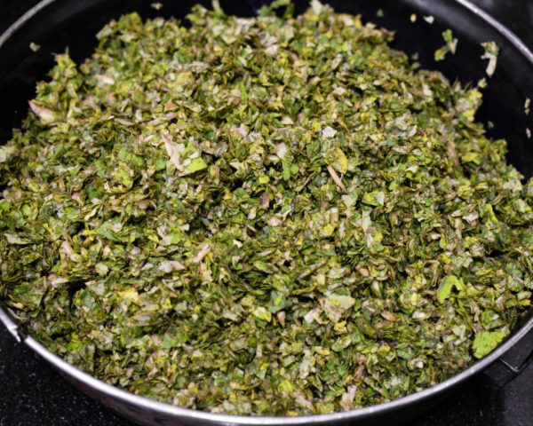 To chopped Colocasia leaves add finely chopped onion and green chillies. Add Besan, Red Chilli Powder, Turmeric Powder, Hing and Salt and mix all ingredients with chopped colocasia leaves nicely.
